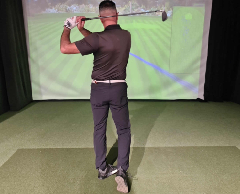 Golfer reviewing golf video analysis on Austin studio monitor