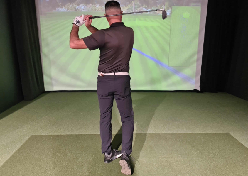 Golfer reviewing golf video analysis on Austin studio monitor