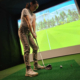 New golfer receiving beginner golf coaching on swing basics at indoor facility