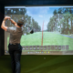 Man practicing drives in a golf simulator receiving golf coaching