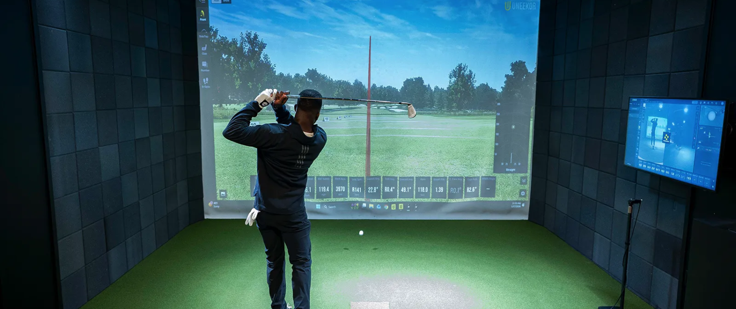 Man swinging in golf simulator using his golf membership