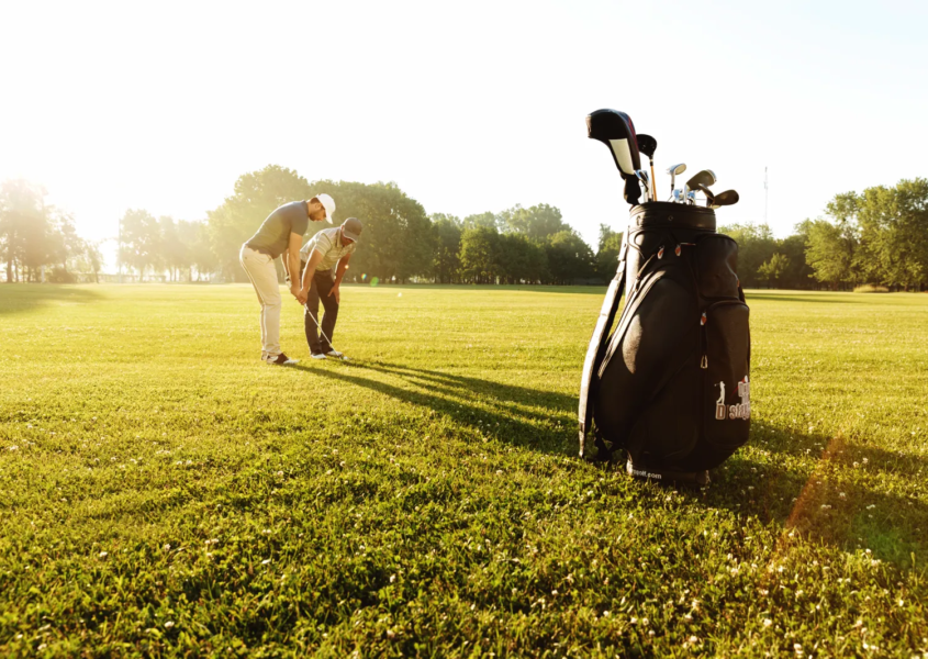 Golf instructor providing one-on-one attention during private golf lessons session