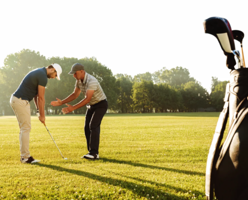 Golf instructor teaching golf lessons for beginners with focus on proper grip