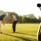 Golf instructor teaching golf lessons for beginners with focus on proper grip